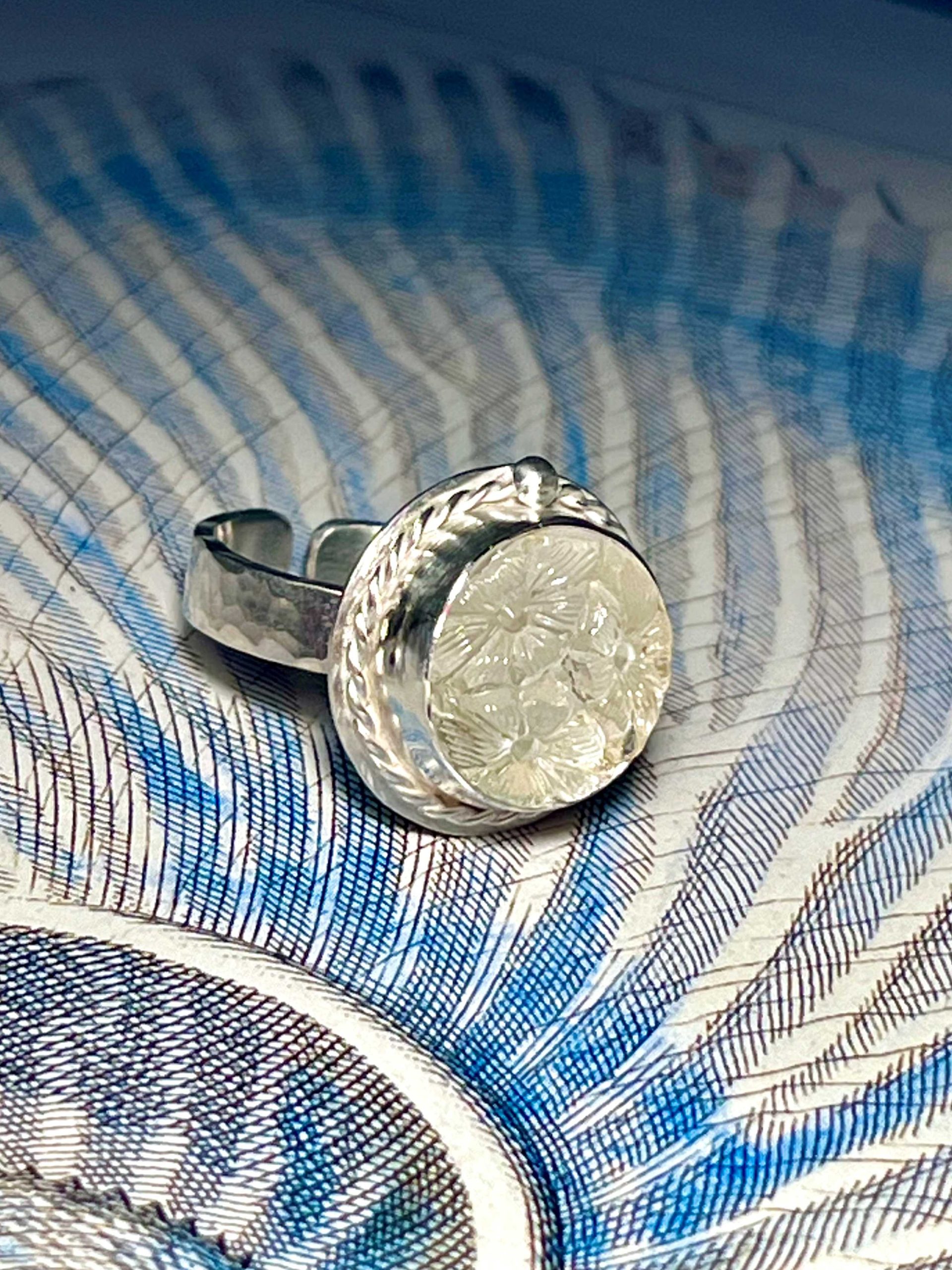 Bague en argent et cabochon de verre Art Déco décoré de trois fleurs en relief.