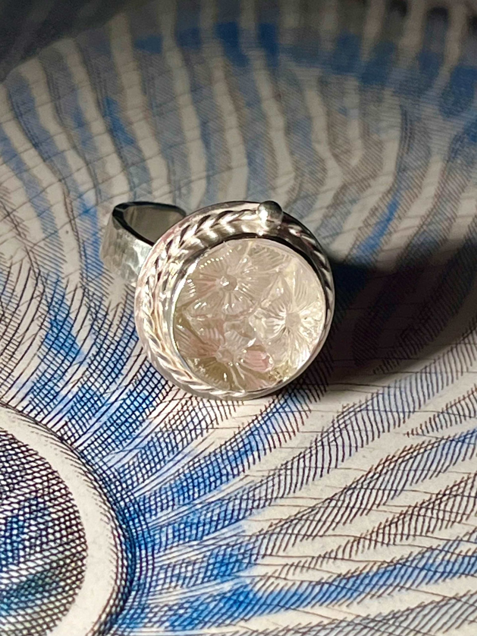 Bague en argent et cabochon de verre Art Déco décoré de trois fleurs en relief.