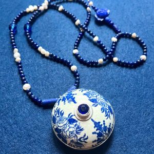 Collier composé d'un couvercle en faïence à décor bleu et blanc du XVII eme siècle, de perles de lapis lazuli, de perles d'eau douce, d'une pate de verre et un cristal de Bohème bleu dans un serti argent.