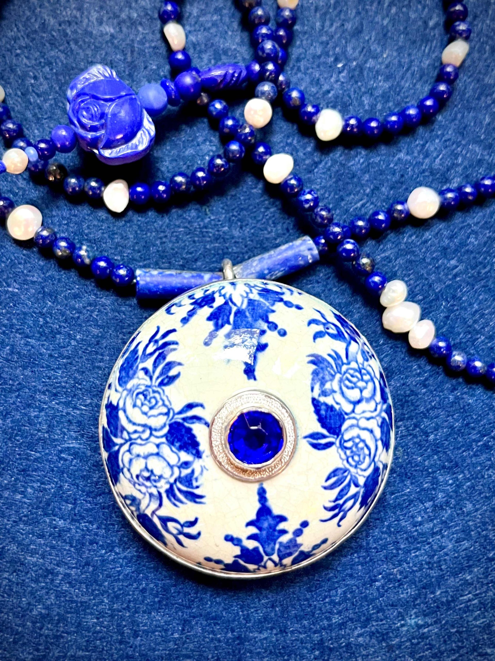 Collier composé d'un couvercle en faïence à décor bleu et blanc du XVII eme siècle, de perles de lapis lazuli, de perles d'eau douce, d'une pate de verre et un cristal de Bohème bleu dans un serti argent. 
