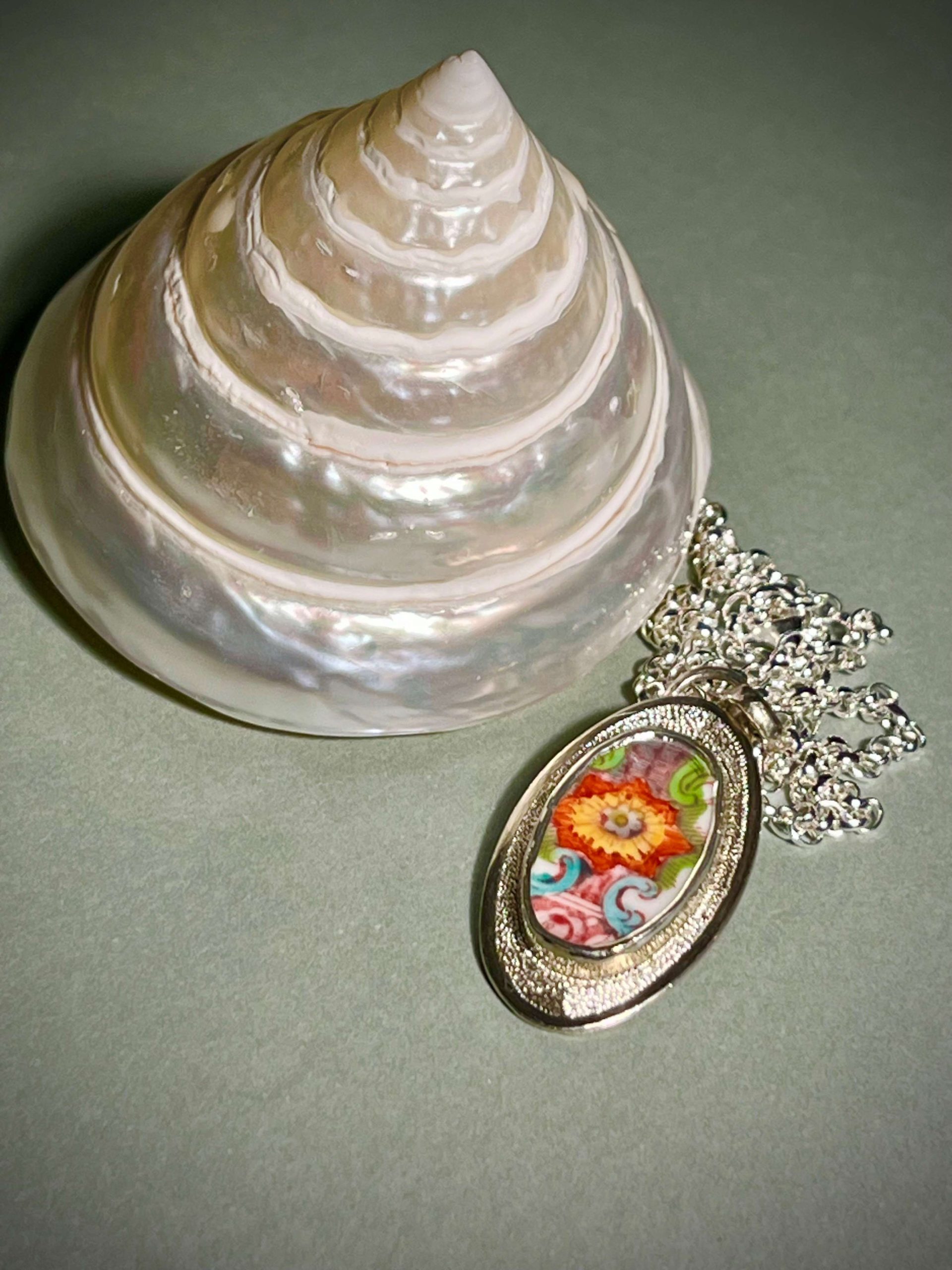 Pendentif avec en serti un morceau de porcelaine du XVIII eme siècle à décor fleuri.