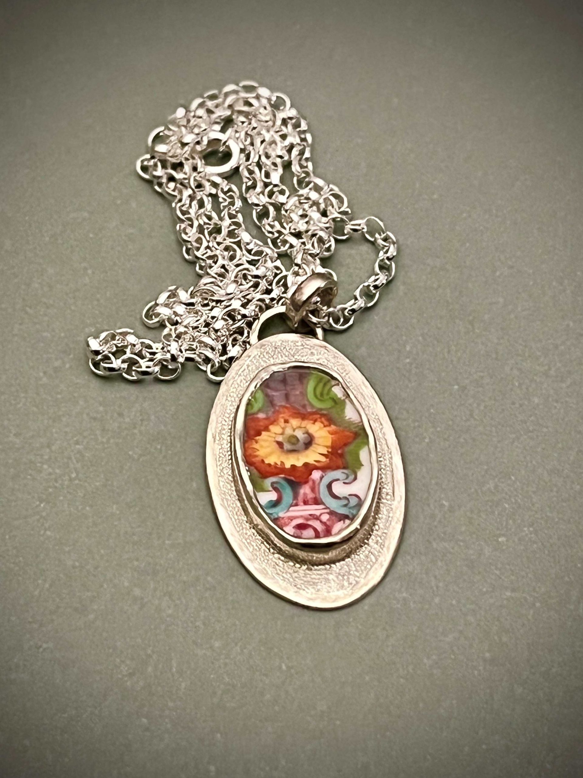 Pendentif avec en serti un morceau de porcelaine du XVIII eme siècle à décor fleuri.